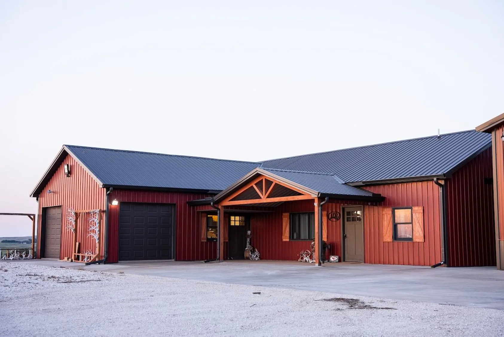 Large red barn with metal roofing and multiple sections, showing quality agricultural buildings that add value to rural properties