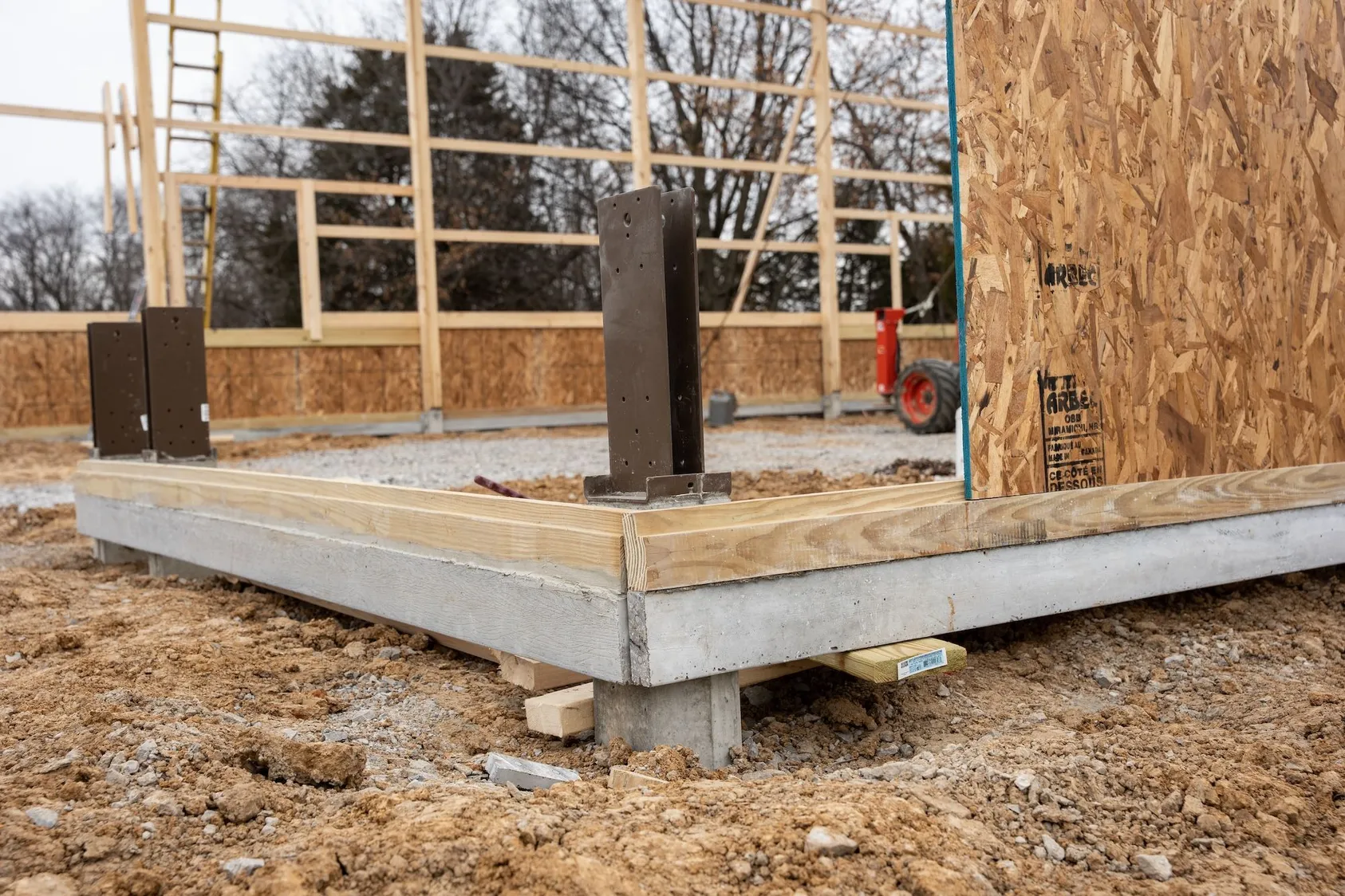 Wooden frame construction of small house or cabin on concrete foundation, showing OSB sheathing and timber framing for tiny house or vacation rental development