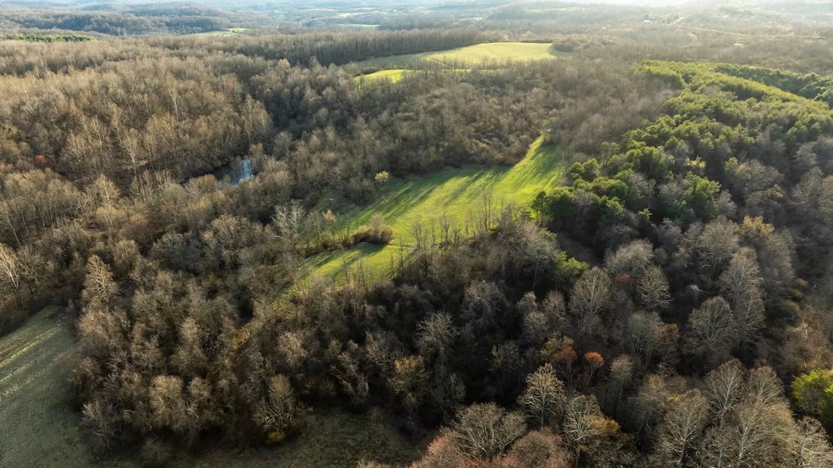 Aerial view of rural property showing fields, wooded areas, and access roads, illustrating strategic land management planning for wildlife habitat