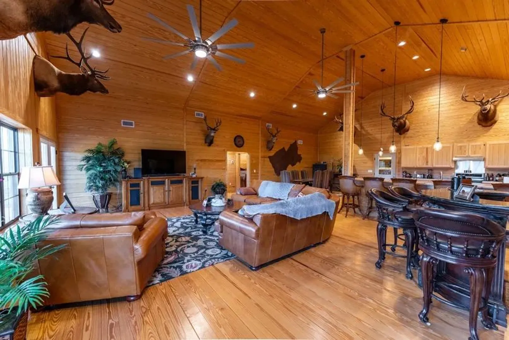 Spacious ranch home interior with stone fireplace, wooden beams, and rustic furniture, showcasing the quality living accommodations on the property