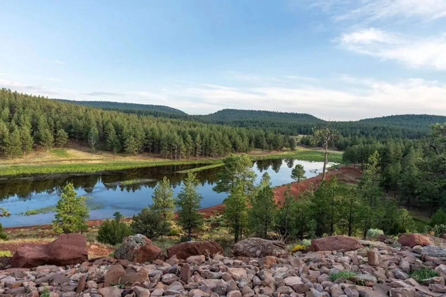 Aerial view of pristine wilderness landscape with lakes and forested mountains, highlighting the recreational and natural value of the ranch property