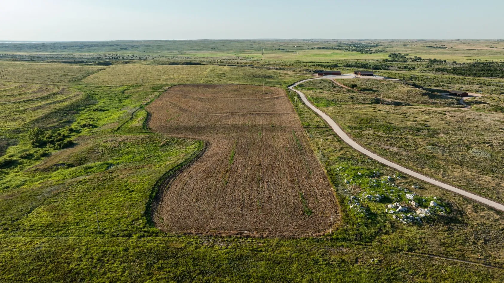 Aerial view of rectangular agricultural fields with dark soil and access road, showing prime farmland layout and property boundaries for valuation purposes