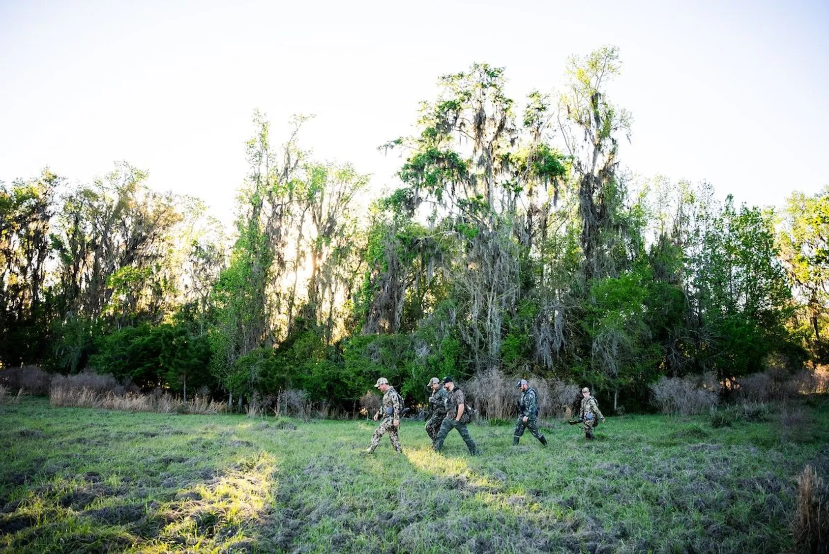 Complete set of Sitka Gear turkey hunting clothing in Optifade Cover camouflage pattern laid out, including hoodie, pants, gloves, and hat for full concealment